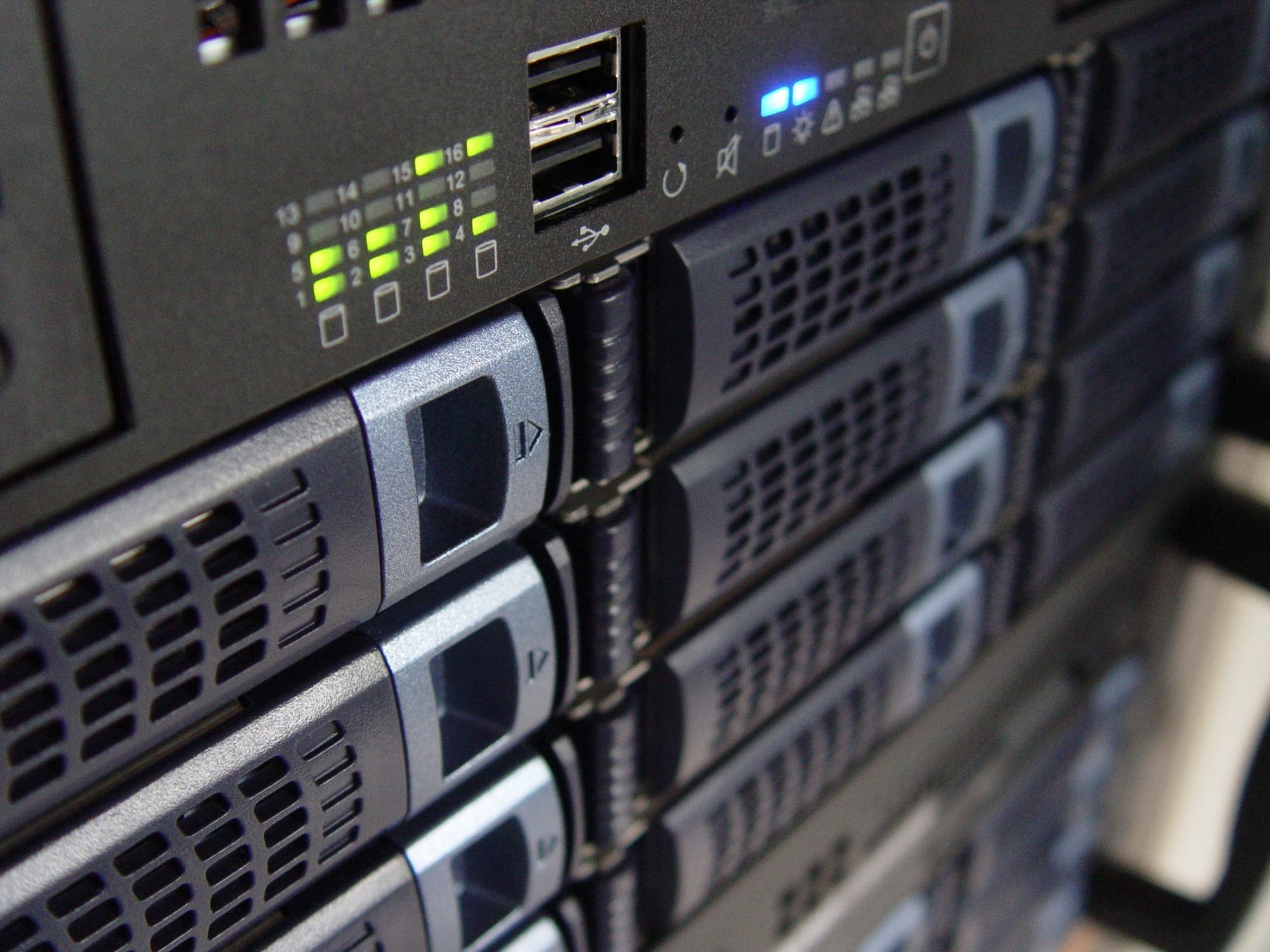 Close-up of enterprise server racks with status lights, representing self-hosted infrastructure and in-house data ownership.